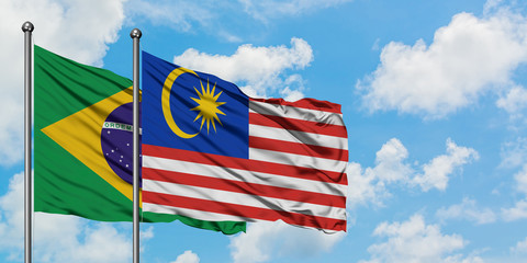 Brazil and Malaysia flag waving in the wind against white cloudy blue sky together. Diplomacy concept, international relations.