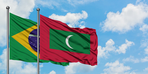 Brazil and Maldives flag waving in the wind against white cloudy blue sky together. Diplomacy concept, international relations.