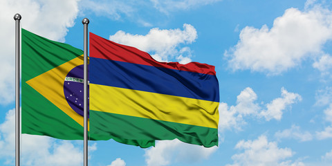 Brazil and Mauritius flag waving in the wind against white cloudy blue sky together. Diplomacy concept, international relations.