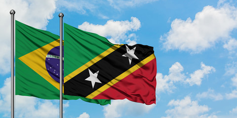 Brazil and Saint Kitts And Nevis flag waving in the wind against white cloudy blue sky together. Diplomacy concept, international relations.