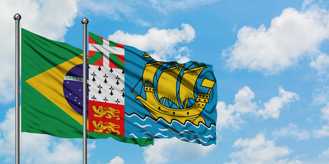 Brazil and Saint Pierre And Miquelon flag waving in the wind against white cloudy blue sky together. Diplomacy concept, international relations.