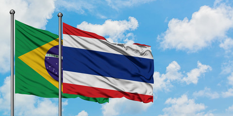 Brazil and Thailand flag waving in the wind against white cloudy blue sky together. Diplomacy concept, international relations.