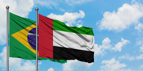 Brazil and United Arab Emirates flag waving in the wind against white cloudy blue sky together. Diplomacy concept, international relations.
