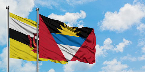 Brunei and Antigua and Barbuda flag waving in the wind against white cloudy blue sky together. Diplomacy concept, international relations.