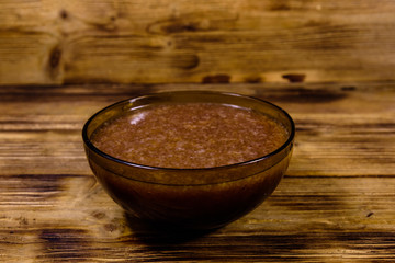 Glass bowl with catfish caviar on wooden table