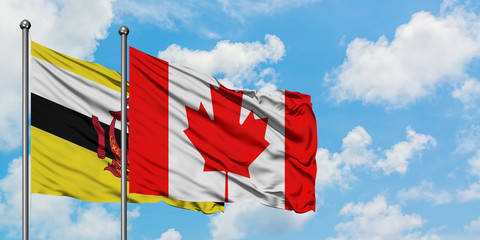 Brunei and Canada flag waving in the wind against white cloudy blue sky together. Diplomacy concept, international relations.