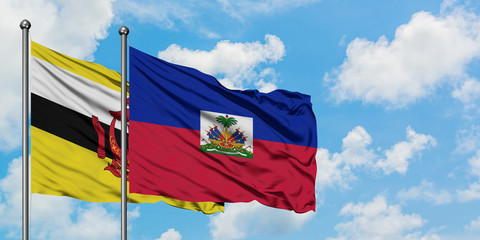 Brunei and Haiti flag waving in the wind against white cloudy blue sky together. Diplomacy concept, international relations.