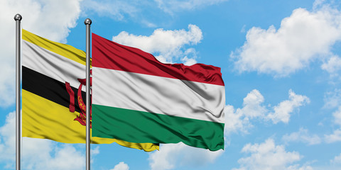 Brunei and Hungary flag waving in the wind against white cloudy blue sky together. Diplomacy concept, international relations.