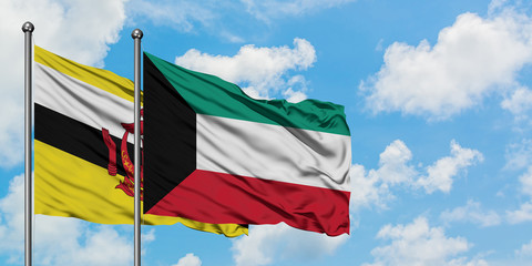 Brunei and Kuwait flag waving in the wind against white cloudy blue sky together. Diplomacy concept, international relations.