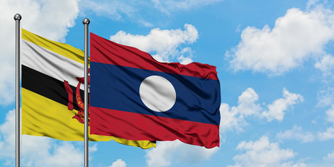 Brunei and Laos flag waving in the wind against white cloudy blue sky together. Diplomacy concept, international relations.