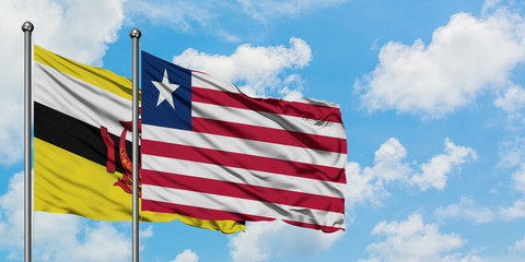 Brunei and Liberia flag waving in the wind against white cloudy blue sky together. Diplomacy concept, international relations.