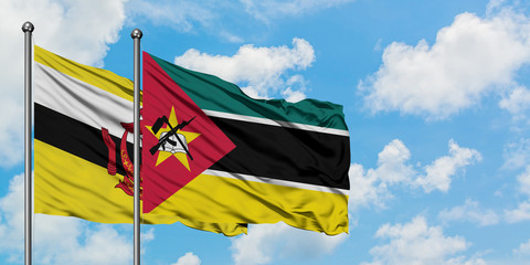 Brunei and Mozambique flag waving in the wind against white cloudy blue sky together. Diplomacy concept, international relations.
