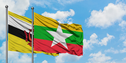 Brunei and Myanmar flag waving in the wind against white cloudy blue sky together. Diplomacy concept, international relations.