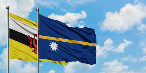Brunei and Nauru flag waving in the wind against white cloudy blue sky together. Diplomacy concept, international relations.