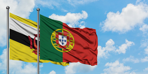 Brunei and Portugal flag waving in the wind against white cloudy blue sky together. Diplomacy concept, international relations.
