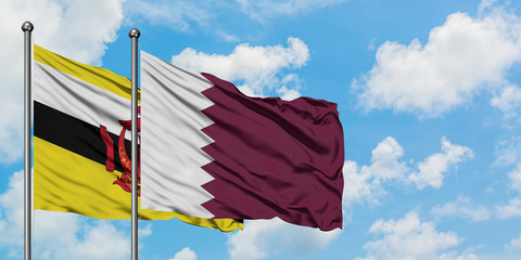 Brunei and Qatar flag waving in the wind against white cloudy blue sky together. Diplomacy concept, international relations.