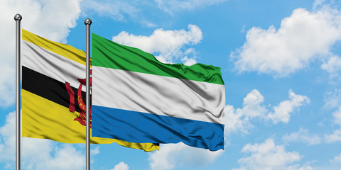 Brunei and Sierra Leone flag waving in the wind against white cloudy blue sky together. Diplomacy concept, international relations.