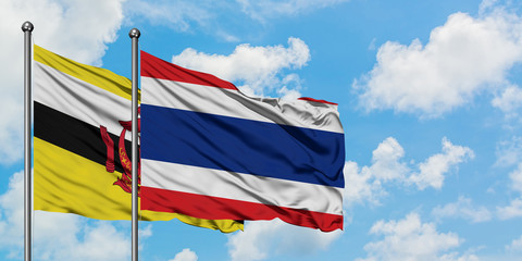 Brunei and Thailand flag waving in the wind against white cloudy blue sky together. Diplomacy concept, international relations.