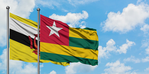 Brunei and Togo flag waving in the wind against white cloudy blue sky together. Diplomacy concept, international relations.