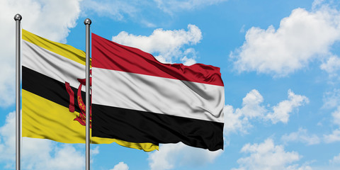 Brunei and Yemen flag waving in the wind against white cloudy blue sky together. Diplomacy concept, international relations.