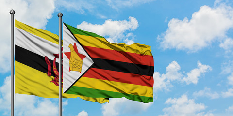Brunei and Zimbabwe flag waving in the wind against white cloudy blue sky together. Diplomacy concept, international relations.