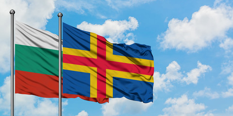 Bulgaria and Aland Islands flag waving in the wind against white cloudy blue sky together. Diplomacy concept, international relations.