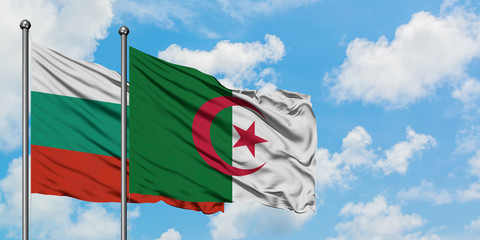 Bulgaria and Algeria flag waving in the wind against white cloudy blue sky together. Diplomacy...