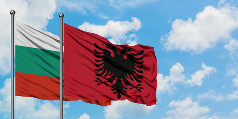 Bulgaria and Albania flag waving in the wind against white cloudy blue sky together. Diplomacy concept, international relations.