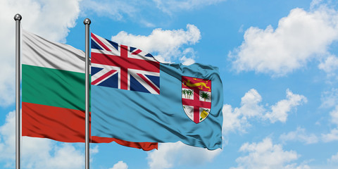 Bulgaria and Fiji flag waving in the wind against white cloudy blue sky together. Diplomacy concept, international relations.