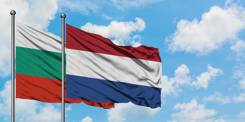 Bulgaria and Netherlands flag waving in the wind against white cloudy blue sky together. Diplomacy concept, international relations.