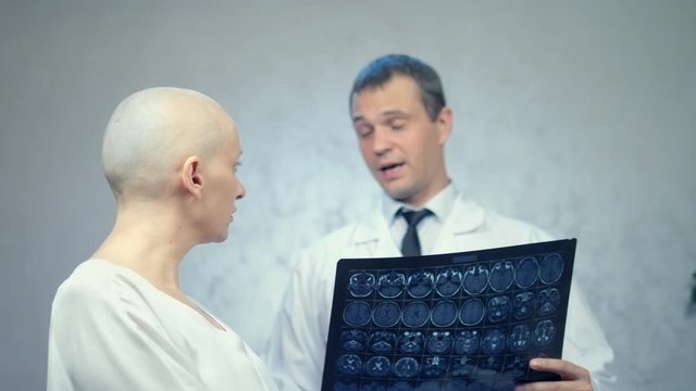young bald woman at the doctor’s office, consultations on the results of tomography, good news.