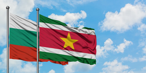 Bulgaria and Suriname flag waving in the wind against white cloudy blue sky together. Diplomacy concept, international relations.