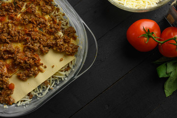 Cooking Italian lasagna, layering, vegetables and mazarella cheese. Background for design. Top view cooking process.