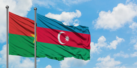 Burkina Faso and Azerbaijan flag waving in the wind against white cloudy blue sky together. Diplomacy concept, international relations.