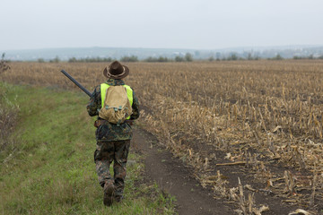 Hunting period, autumn season open. A hunter with a gun in his hands in hunting clothes in the...