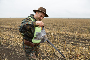 Hunting period, autumn season open. A hunter with a gun in his hands in hunting clothes in the...