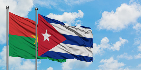 Burkina Faso and Cuba flag waving in the wind against white cloudy blue sky together. Diplomacy concept, international relations.