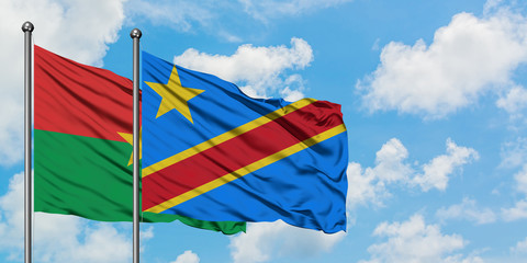 Burkina Faso and Congo flag waving in the wind against white cloudy blue sky together. Diplomacy concept, international relations.