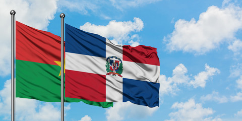 Burkina Faso and Dominican Republic flag waving in the wind against white cloudy blue sky together. Diplomacy concept, international relations.
