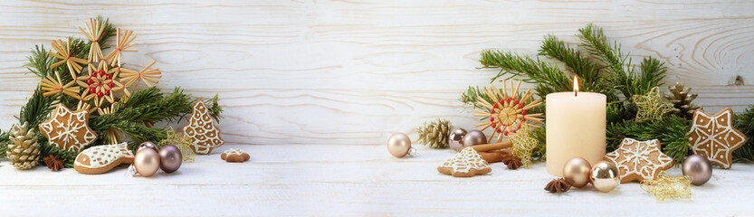 Christmas decoration and burning candle on white painted rustic wood, panoramic format with copy...