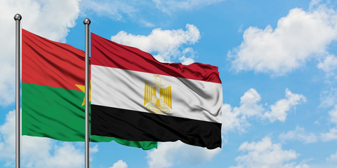 Burkina Faso and Egypt flag waving in the wind against white cloudy blue sky together. Diplomacy concept, international relations.