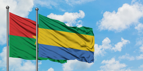 Burkina Faso and Gabon flag waving in the wind against white cloudy blue sky together. Diplomacy concept, international relations.