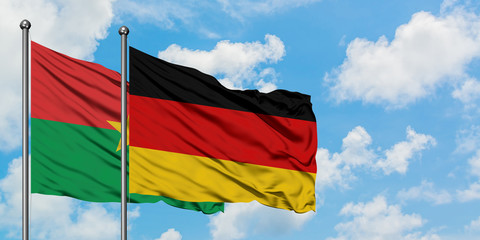 Burkina Faso and Germany flag waving in the wind against white cloudy blue sky together. Diplomacy concept, international relations.