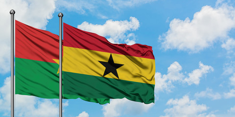 Burkina Faso and Ghana flag waving in the wind against white cloudy blue sky together. Diplomacy concept, international relations.