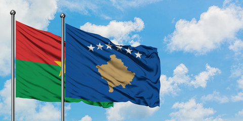 Burkina Faso and Kosovo flag waving in the wind against white cloudy blue sky together. Diplomacy concept, international relations.