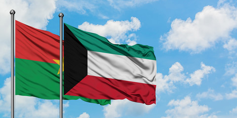 Burkina Faso and Kuwait flag waving in the wind against white cloudy blue sky together. Diplomacy concept, international relations.