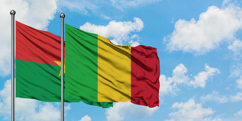 Burkina Faso and Mali flag waving in the wind against white cloudy blue sky together. Diplomacy concept, international relations.