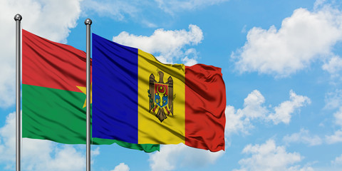 Burkina Faso and Moldova flag waving in the wind against white cloudy blue sky together. Diplomacy concept, international relations.