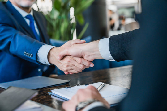 Hands Of Senior And Young Businessmen Shaking After Agreement On Meeting