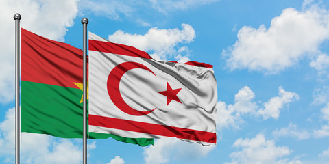 Burkina Faso and Northern Cyprus flag waving in the wind against white cloudy blue sky together. Diplomacy concept, international relations.